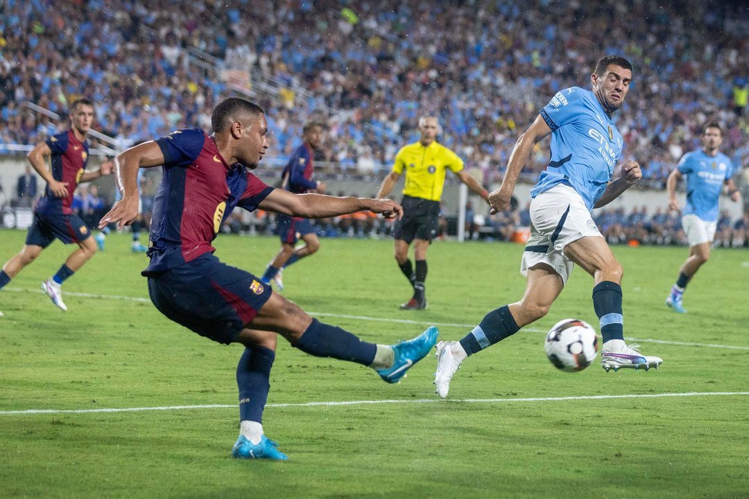 El delantero del Barcelona español, el brasileño Vitor Roque (i) encara la marca del centrocampista del Manchester City inglés Mateo Kovacic (d) durante el partido amistoso de pretemporada jugado este martes en la ciudad estadounidense de Orlando (Florida). EFE/EPA/CRISTÓBAL HERRERA-ULASHKEVICH